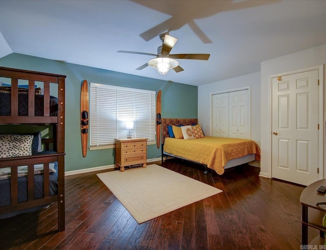 bedroom with baseboards, a ceiling fan, hardwood / wood-style floors, vaulted ceiling, and a closet