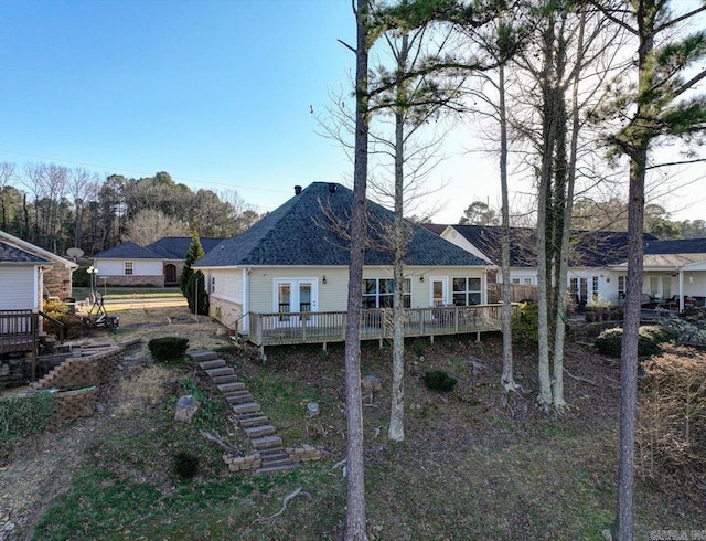 rear view of property featuring french doors, stairway, and a wooden deck