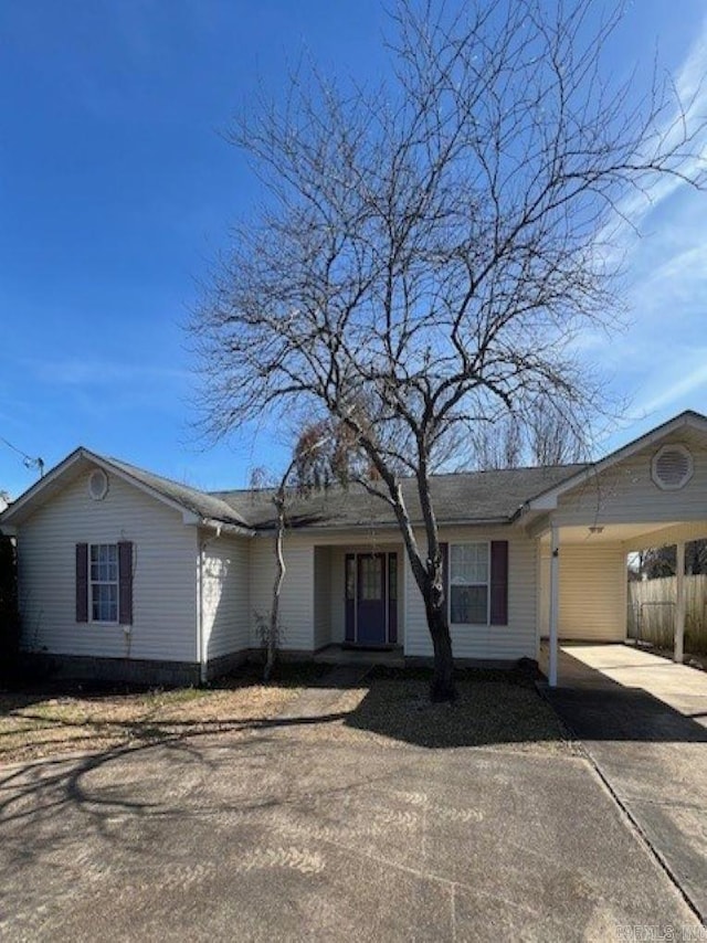 ranch-style house with concrete driveway and an attached carport