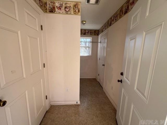 hall featuring visible vents and baseboards