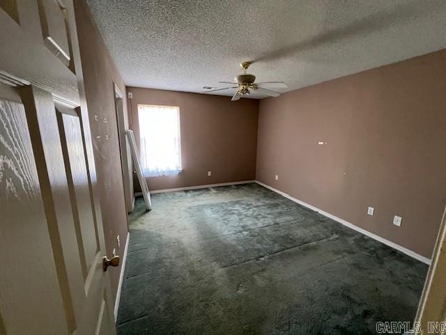 carpeted spare room with a textured ceiling, a ceiling fan, and baseboards