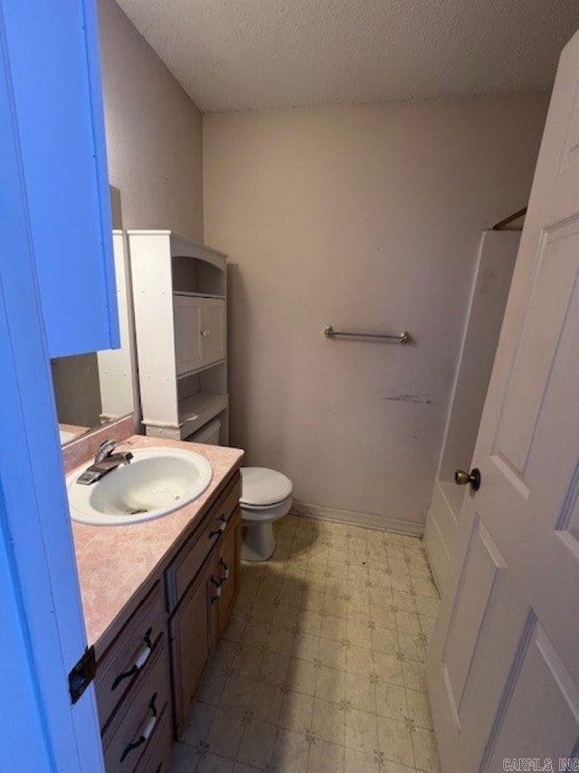 full bath featuring baseboards, toilet, tile patterned floors, a textured ceiling, and vanity