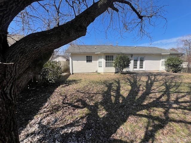 rear view of property with french doors and fence