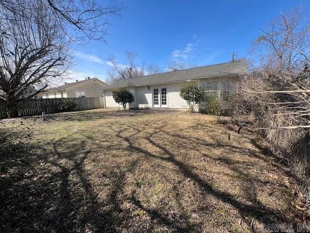 back of house with french doors, a lawn, and fence