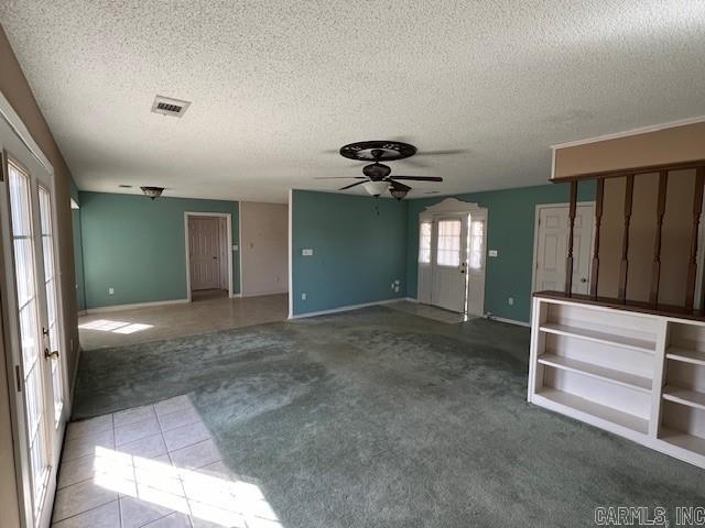 unfurnished room featuring visible vents, ceiling fan, light carpet, and a textured ceiling