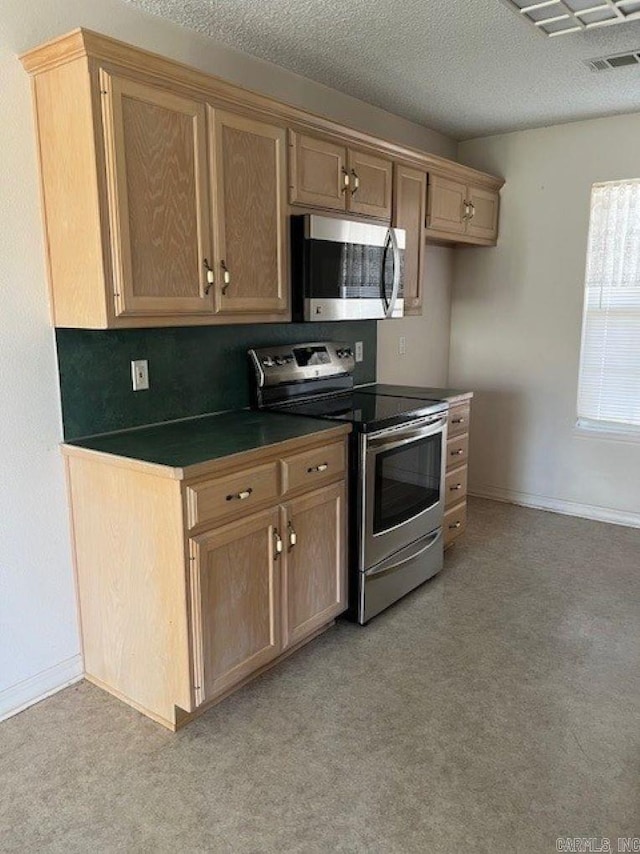 kitchen with baseboards, visible vents, dark countertops, appliances with stainless steel finishes, and a textured ceiling