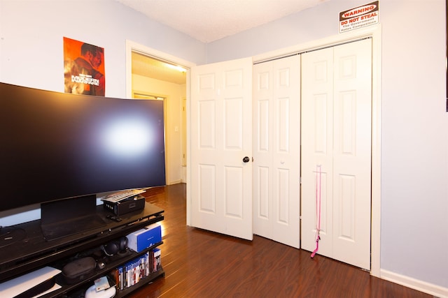 bedroom with a closet and dark wood-style flooring