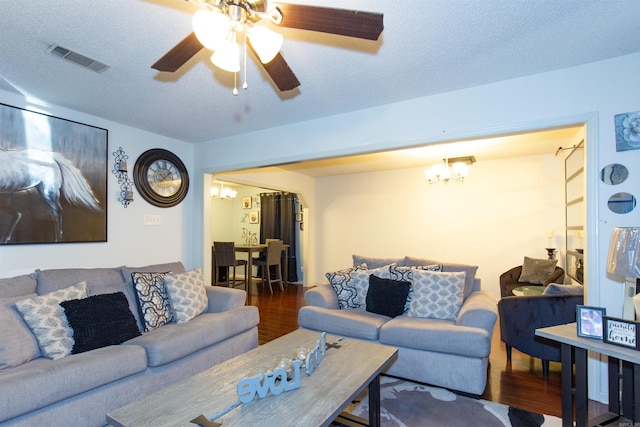 living area with visible vents, a textured ceiling, and wood finished floors