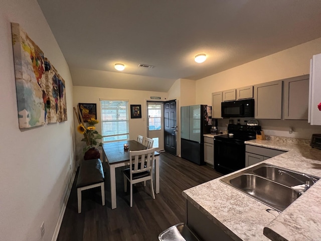 kitchen with light countertops, gray cabinets, visible vents, and black appliances