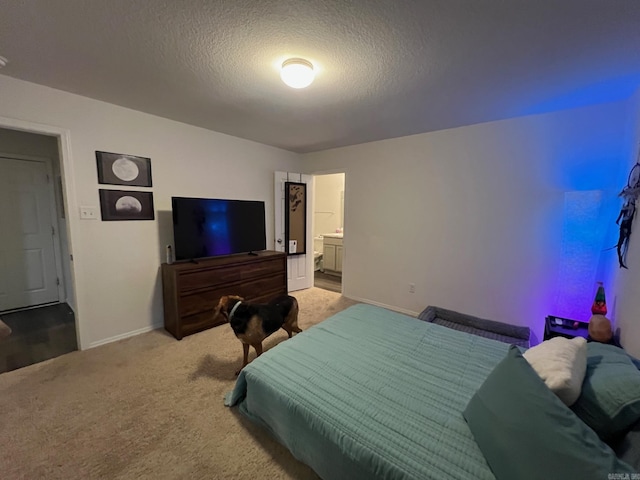 bedroom featuring light carpet, a textured ceiling, and baseboards