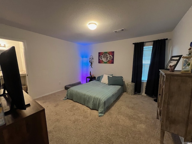 carpeted bedroom featuring baseboards, visible vents, and a textured ceiling