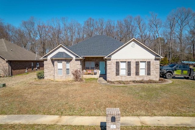 view of front of house featuring brick siding, a front lawn, and roof with shingles