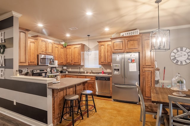 kitchen featuring visible vents, appliances with stainless steel finishes, a breakfast bar, ornamental molding, and a peninsula