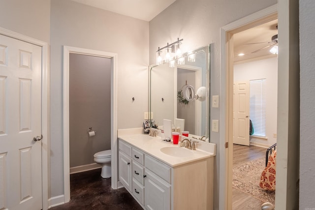 full bathroom featuring toilet, double vanity, a ceiling fan, and a sink