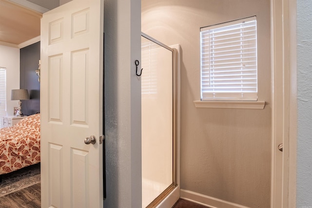 full bathroom featuring ornamental molding, a shower stall, ensuite bath, wood finished floors, and baseboards