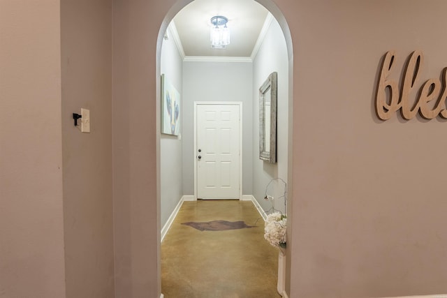 hall featuring ornamental molding, arched walkways, finished concrete flooring, and baseboards