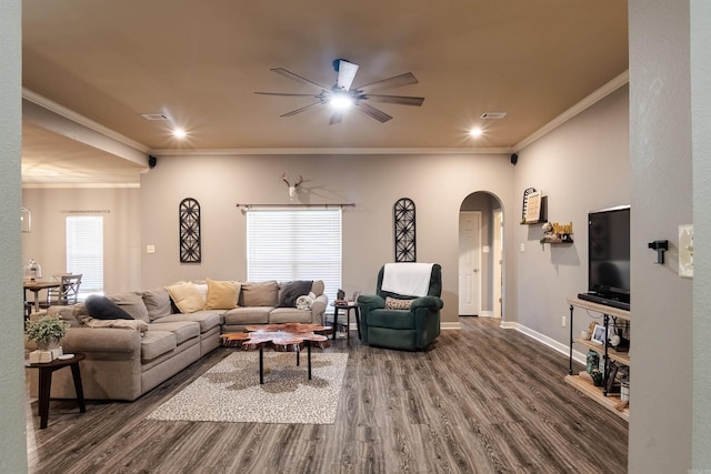 living area featuring baseboards, arched walkways, wood finished floors, and ornamental molding