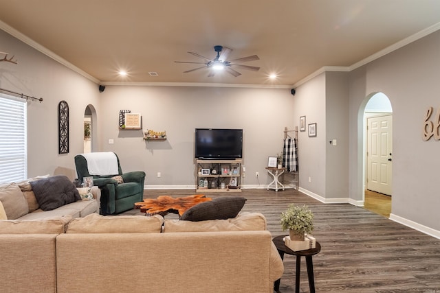 living area featuring dark wood-style floors, arched walkways, crown molding, and baseboards