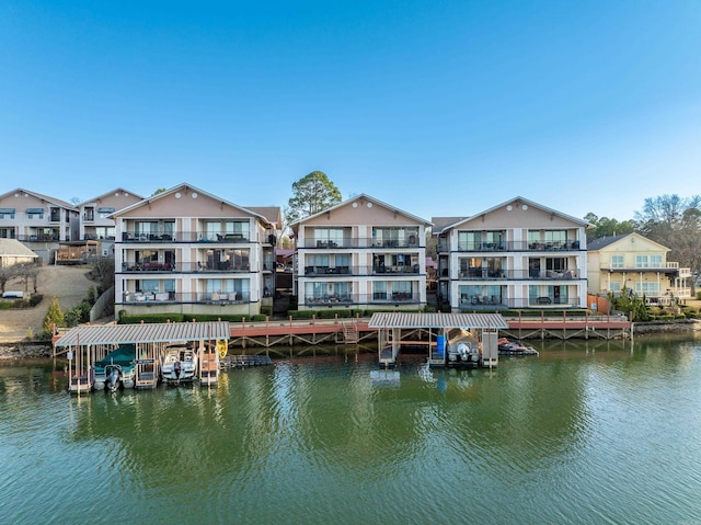 back of property featuring a residential view and a water view