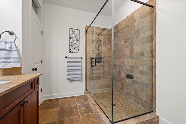 full bath featuring a shower stall, baseboards, and vanity