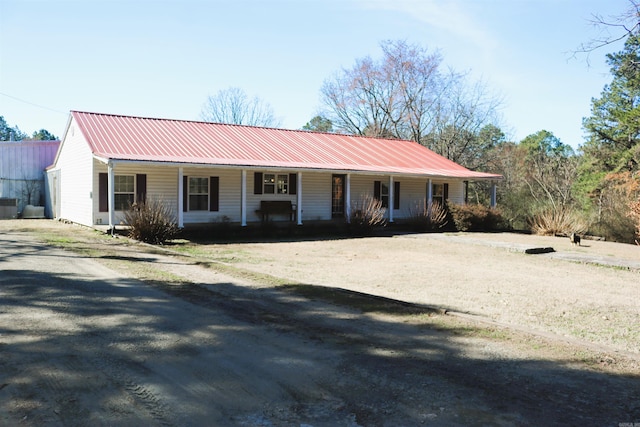 ranch-style home with covered porch and metal roof