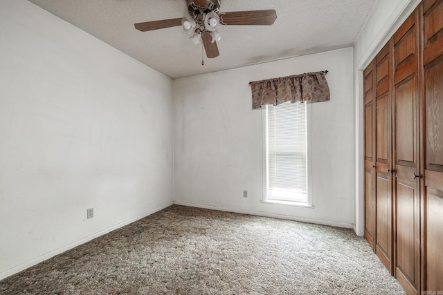 unfurnished bedroom featuring carpet floors, a closet, ceiling fan, a textured ceiling, and baseboards