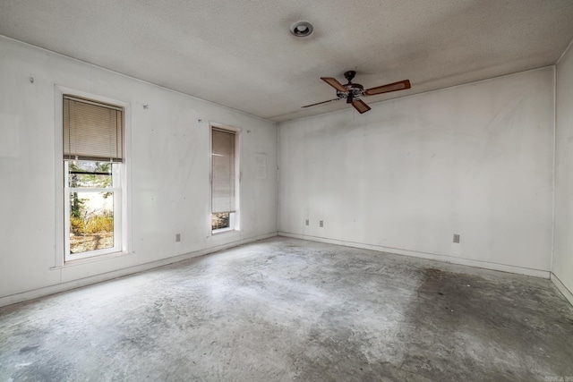 spare room with concrete floors, a textured ceiling, and ceiling fan