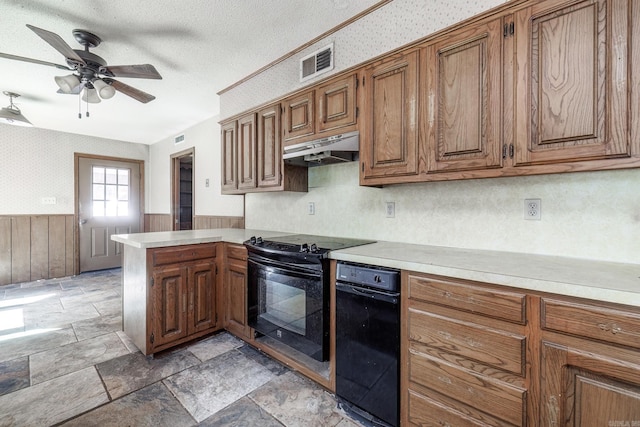 kitchen featuring visible vents, a wainscoted wall, black range with electric stovetop, a peninsula, and under cabinet range hood