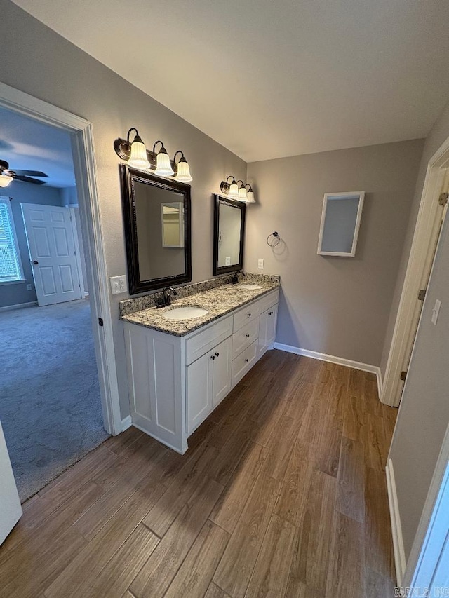 full bath featuring wood finished floors, a sink, a ceiling fan, and baseboards