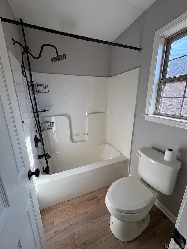 bathroom featuring bathtub / shower combination, wood finished floors, and toilet