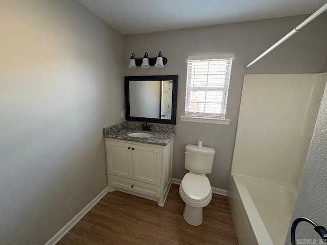 full bathroom with baseboards, toilet, wood finished floors, tub / shower combination, and vanity