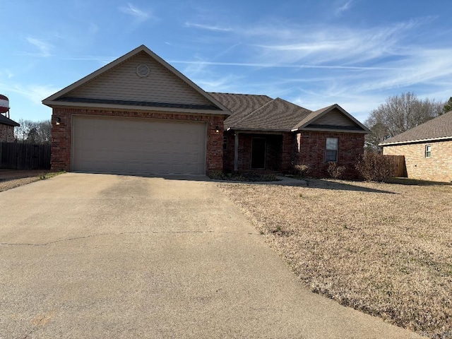 ranch-style house with a garage, driveway, brick siding, and fence