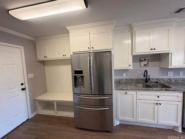 kitchen with wood finish floors, a sink, visible vents, white cabinets, and stainless steel refrigerator with ice dispenser