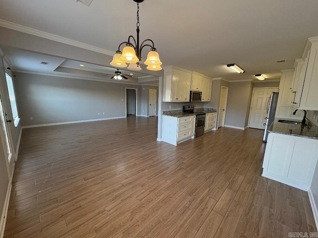 kitchen with crown molding, stainless steel appliances, open floor plan, white cabinetry, and a sink