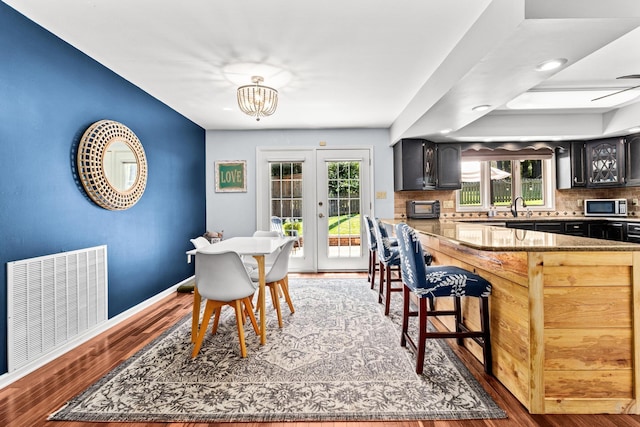 dining area with visible vents, plenty of natural light, baseboards, and wood finished floors