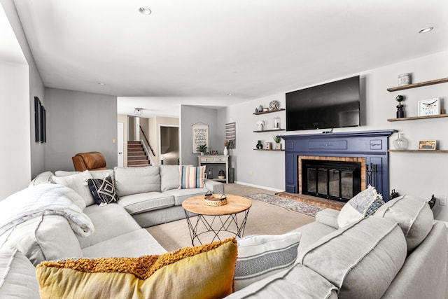 living area with carpet, recessed lighting, a brick fireplace, baseboards, and stairs