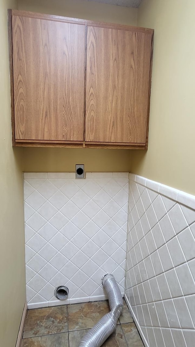 clothes washing area with cabinet space and hookup for an electric dryer