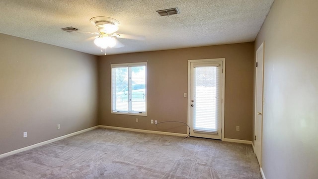 unfurnished room with visible vents, ceiling fan, light carpet, and baseboards