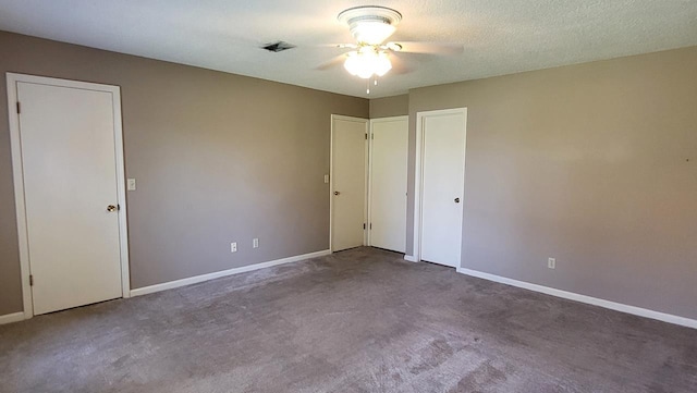 unfurnished bedroom with visible vents, carpet flooring, a textured ceiling, and baseboards