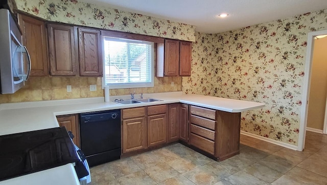 kitchen with baseboards, a sink, black appliances, and wallpapered walls