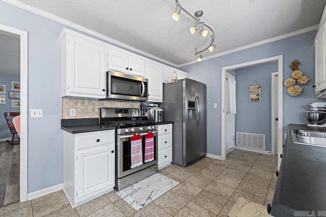 kitchen featuring tasteful backsplash, visible vents, white cabinets, dark countertops, and stainless steel appliances