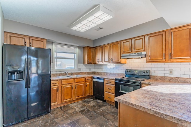 kitchen featuring brown cabinetry, a sink, under cabinet range hood, and black appliances