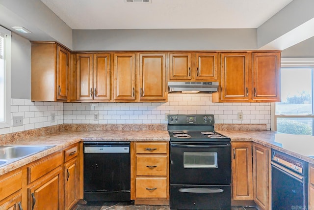 kitchen featuring black appliances, brown cabinets, decorative backsplash, and under cabinet range hood