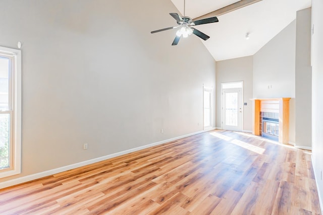 unfurnished living room featuring high vaulted ceiling, a ceiling fan, baseboards, light wood-style floors, and a tiled fireplace