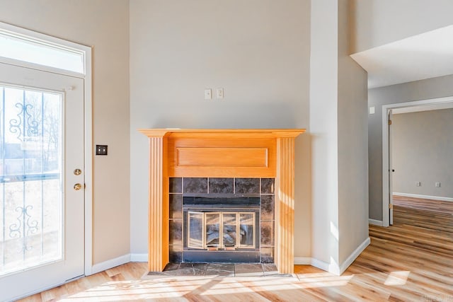 interior space featuring a fireplace, wood finished floors, and baseboards