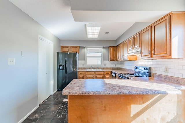 kitchen featuring under cabinet range hood, a peninsula, electric range, brown cabinets, and black refrigerator with ice dispenser