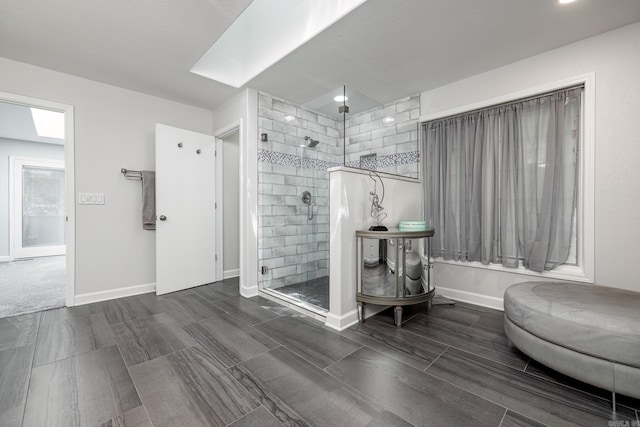 bathroom featuring baseboards and a tile shower