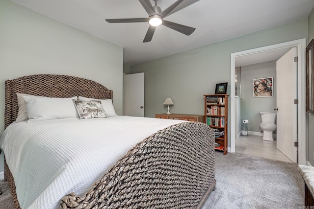 bedroom featuring ensuite bathroom, baseboards, a ceiling fan, and light colored carpet