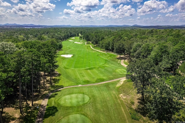aerial view featuring golf course view, a wooded view, and a mountain view