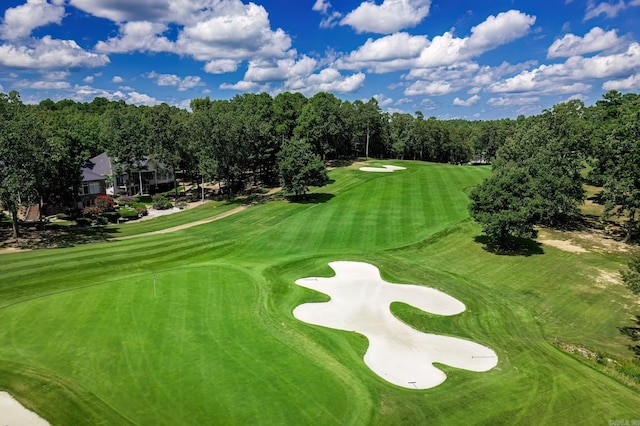 view of community featuring view of golf course and a yard